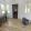 a living room with a table chairs and a plant and windows